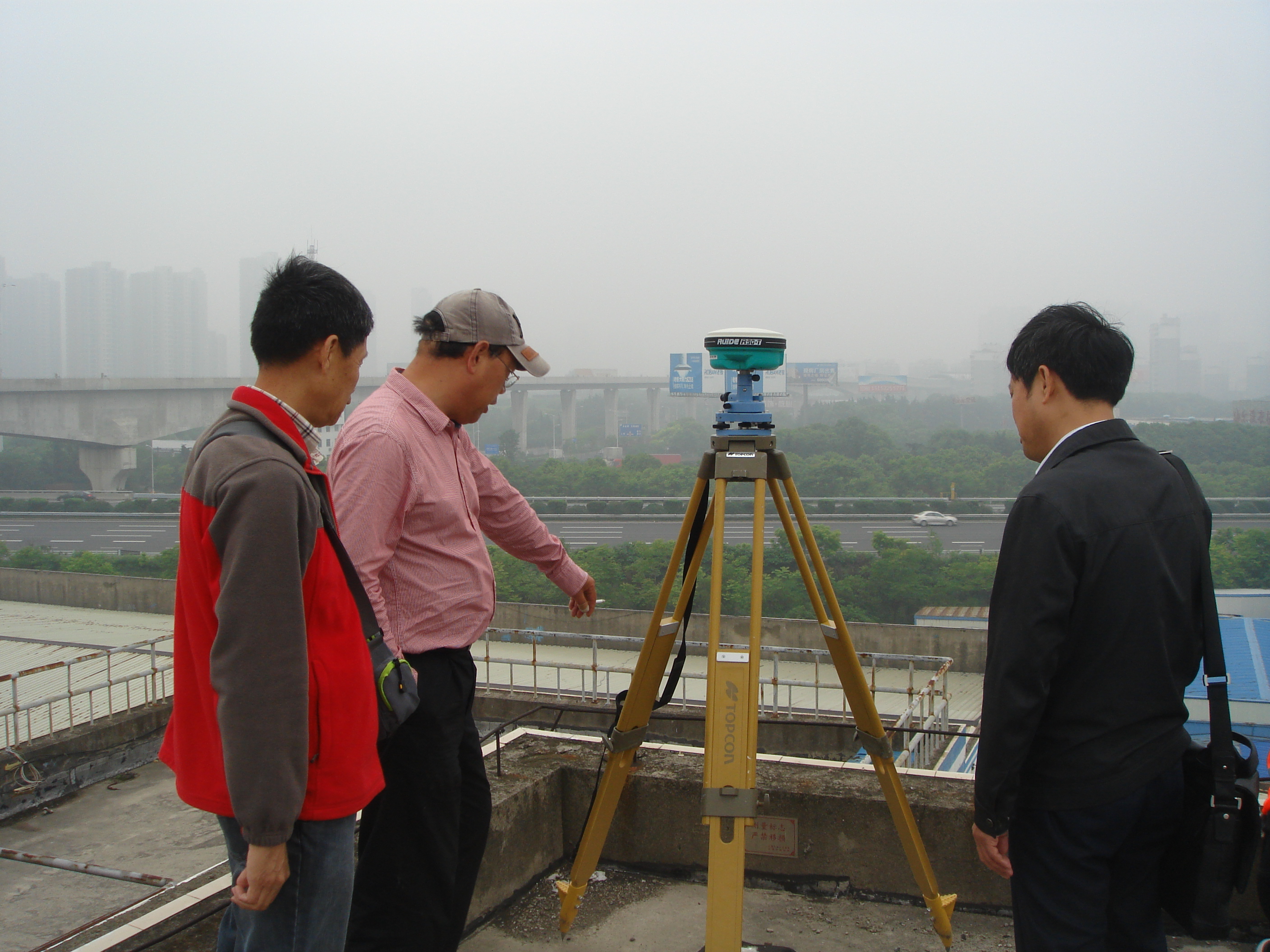 学会专家工作站专家秦政国、朱敏芳、解学虎在锡东立交D级GPS控制点上进行业务指导